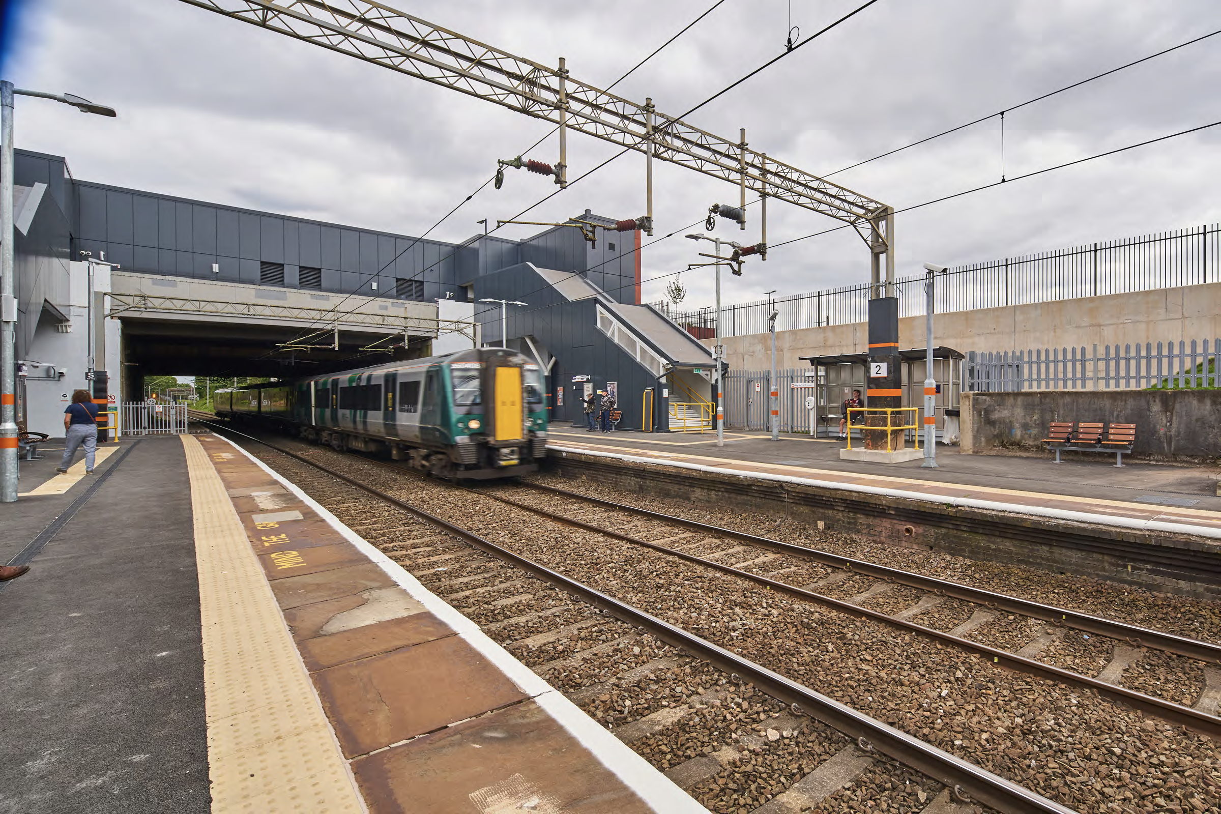 A photo taken from one of the platforms at Perry Barr railway station, looking back on the station building with a train at one of the platforms