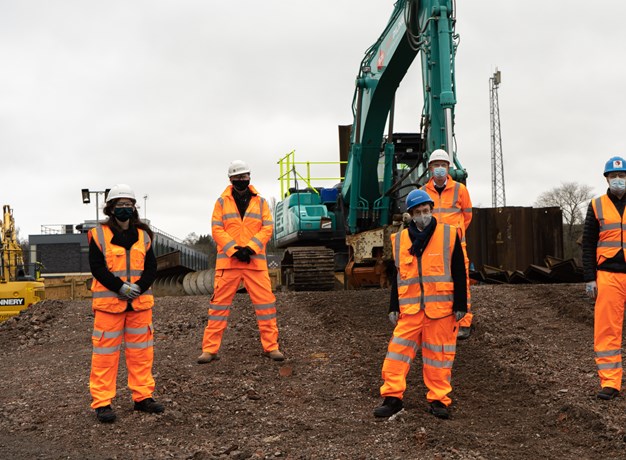 Workers in front of a digger